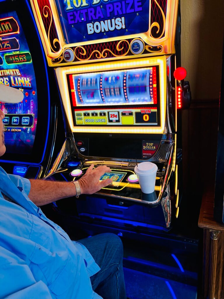 Adult male playing the slot machines.